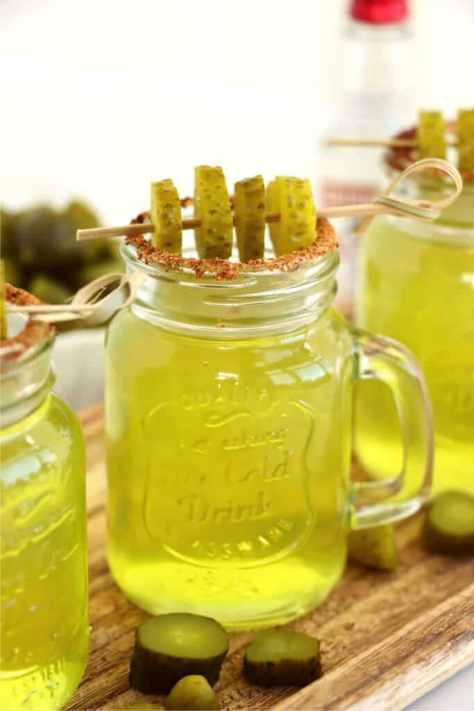 Closeup shot of pickle shot garnished with Tajin and dill pickle slices. 