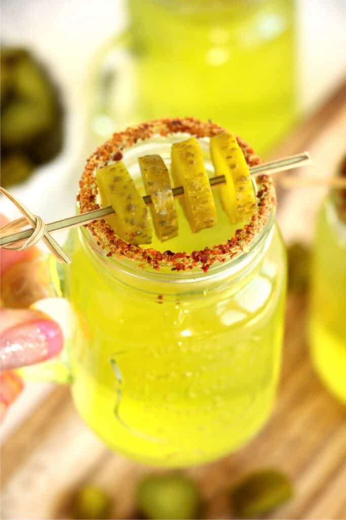 Shot glass filled with pickle shot and garnished with dill pickle slices. 