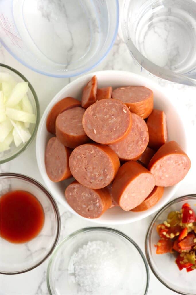 Overhead shot of pickled bologna ingredients in individual bowls on table