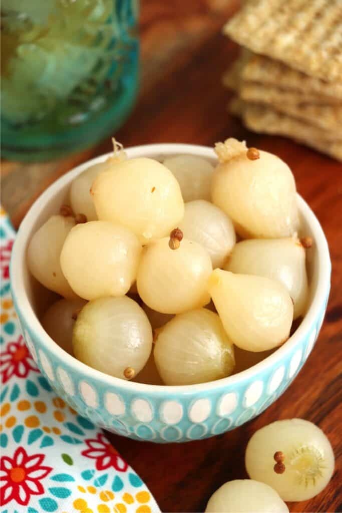 Closeup overhead shot of bowlful of pickled pearl onions. 