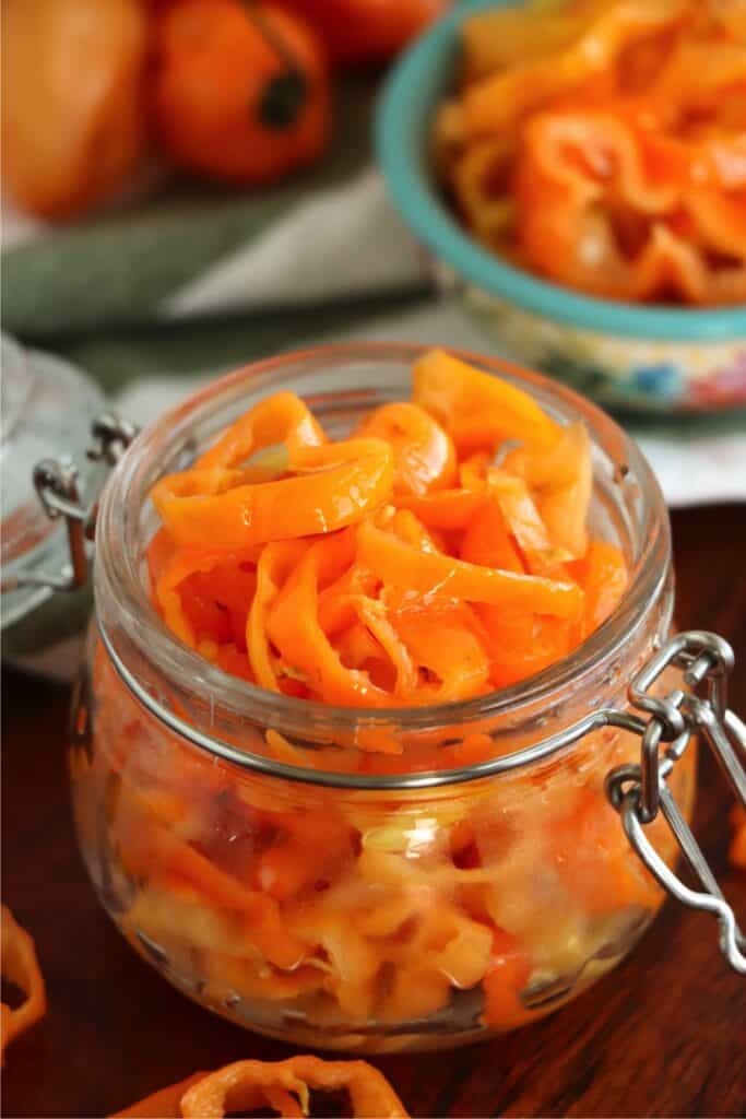 Closeup shot of jarful of sliced pickled habanero peppers. 