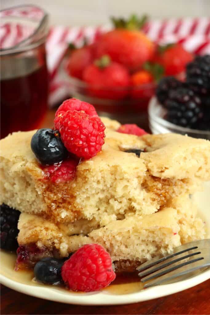 Closeup shot of two slices of sheet pan pancake from mix stacke atop one another on plate. 