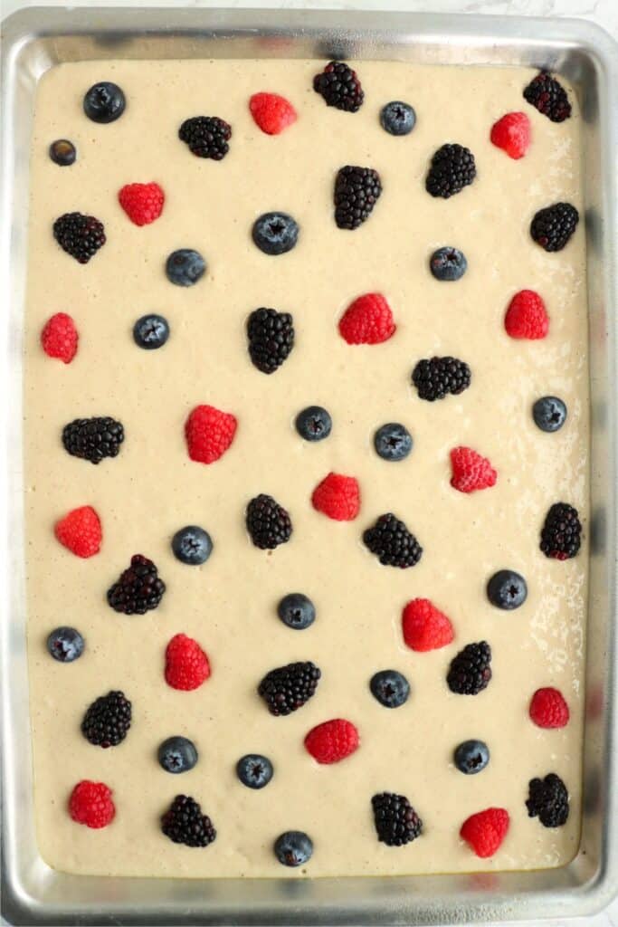 Overhead shot of sheet pan pancake batter toppe with blueberries, raspberries, and blackberries. 