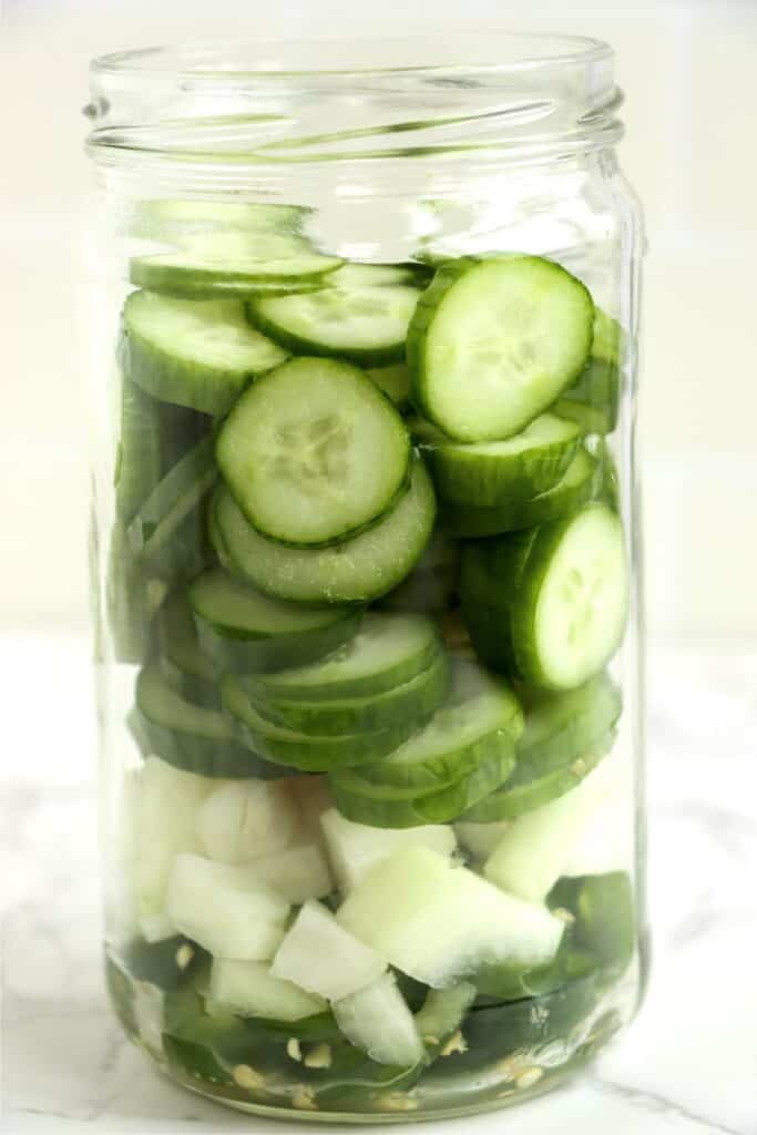 Jarful of cucumbers, jalapenso, onions, and garlic. 