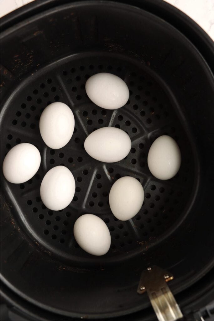 Overhead shot of eggs in air fryer basket. 