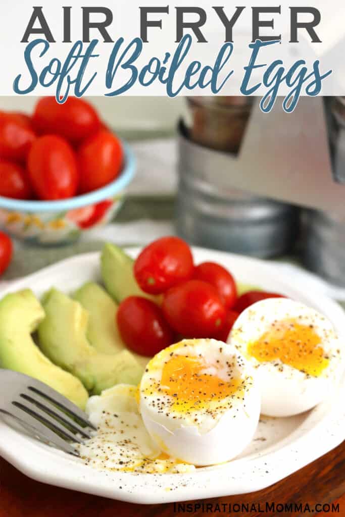 Closeup shot of plate with two air fryer soft boiled eggs, avocado slices and cherry tomatoes.