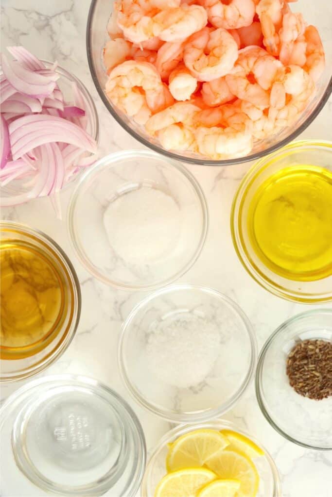 Overhead shot of individual pickled shrimp ingredients in bowls on table.