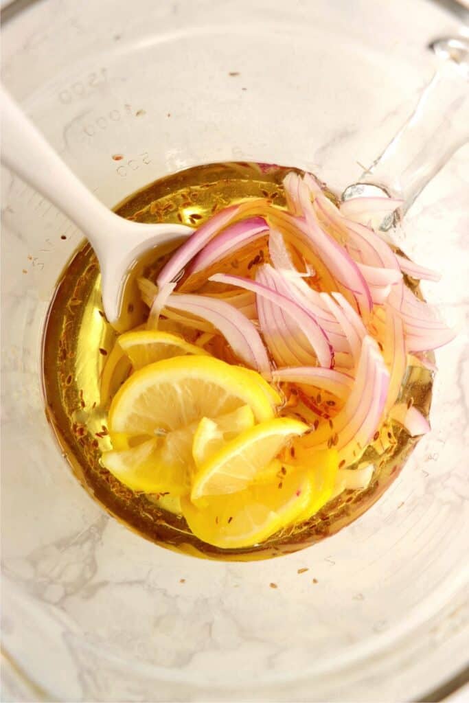 Overhead shot of pickling mixture with onions and lemons.