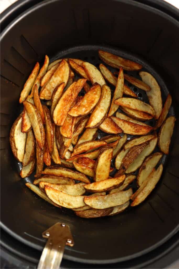 Overhead shot of air fryer steak fries in air fryer basket. 