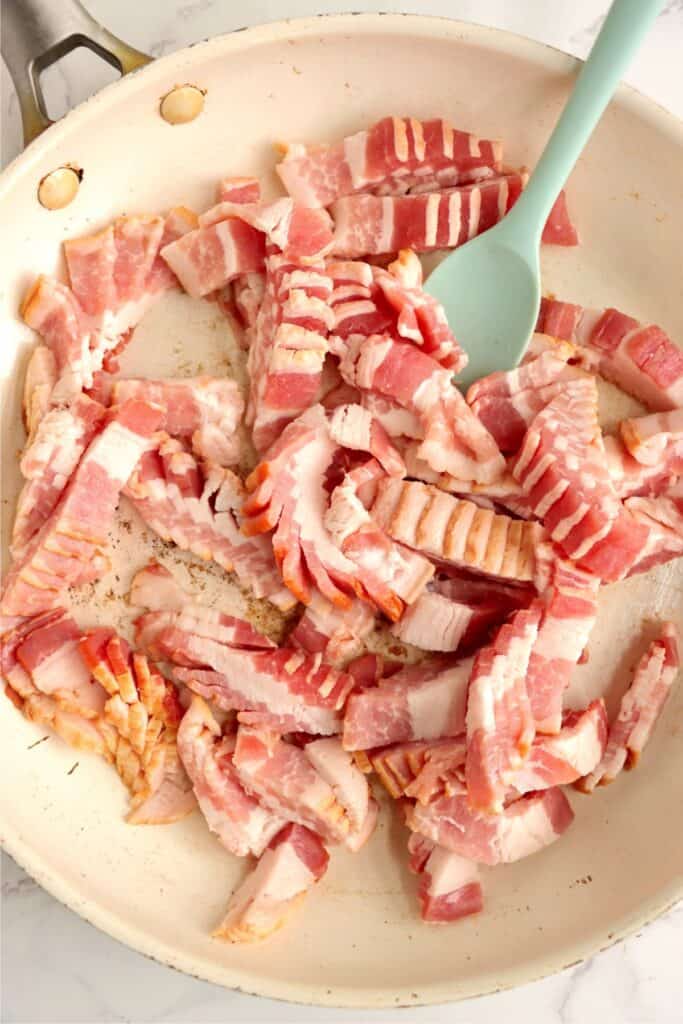 Closeup overhead shot of raw bacon in skillet.