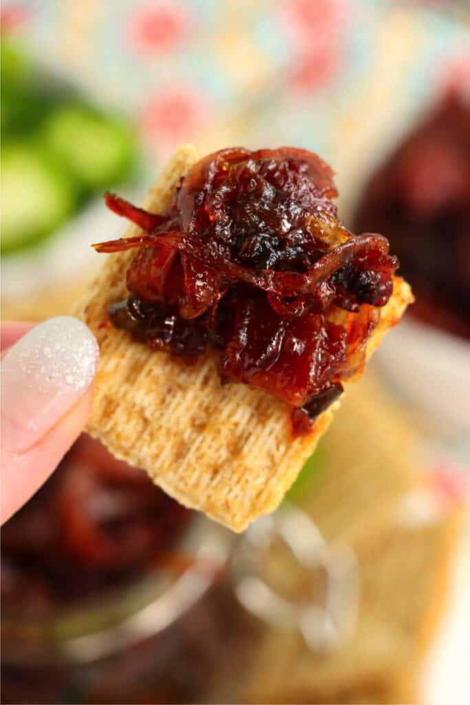 Closeup shot of cracker topped with bacon jalapeno jam. 