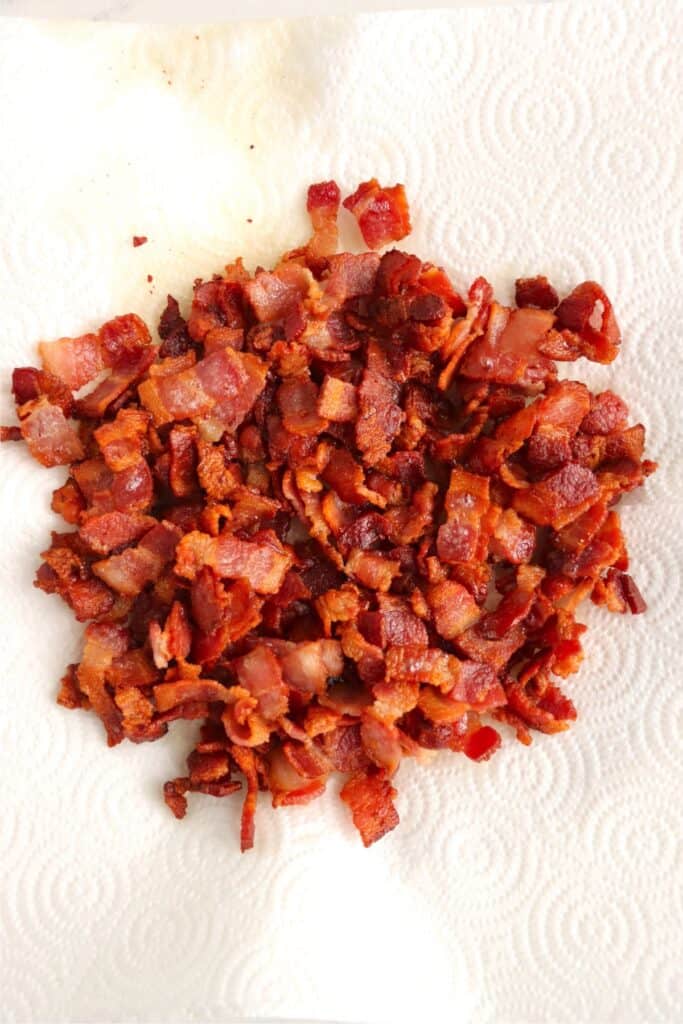 Closeup overhead shot of crispy diced bacon on paper towel. 