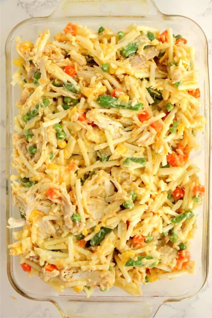 Overhead shot of baking dish full of unbaked chicken hash brown casserole. 