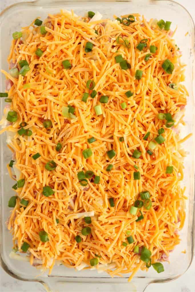 Overhead shot of unbaked ham and cheese hash brown casserole in baking dish.