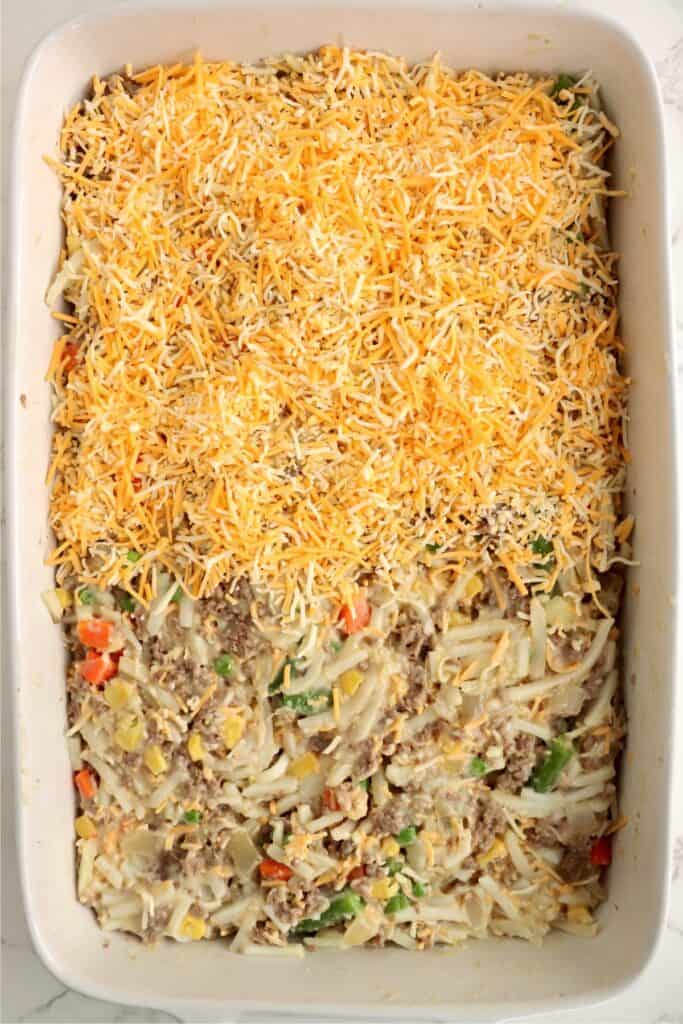 Overhead shot of casserole dish full of unbaked ground beef and hash brown casserole. 