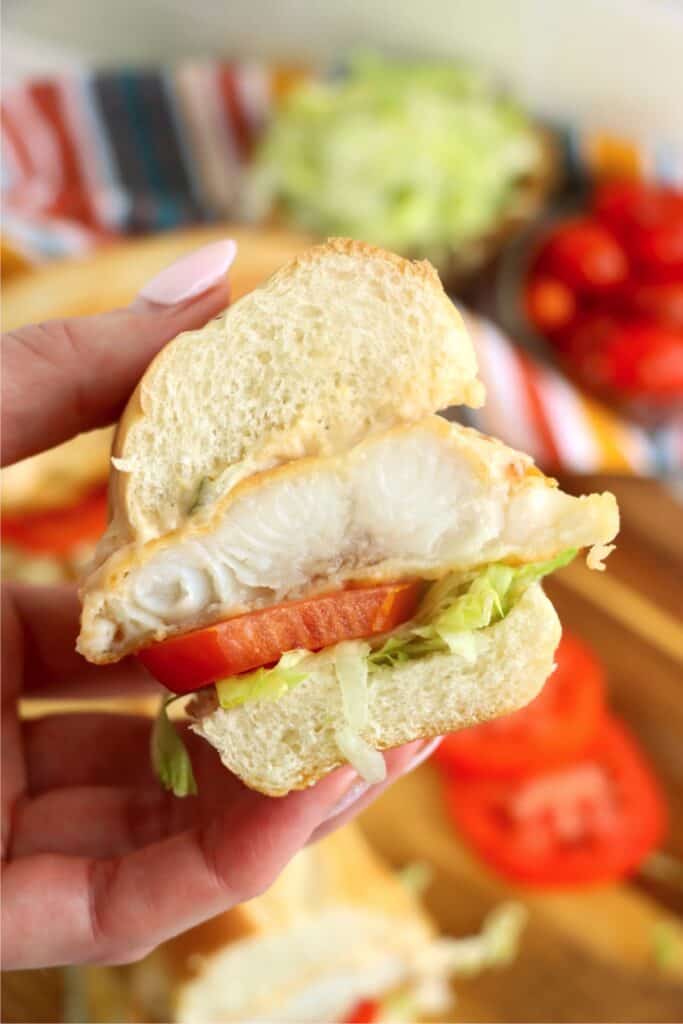 Closeup shot of hand holding half of a catfish po boy.