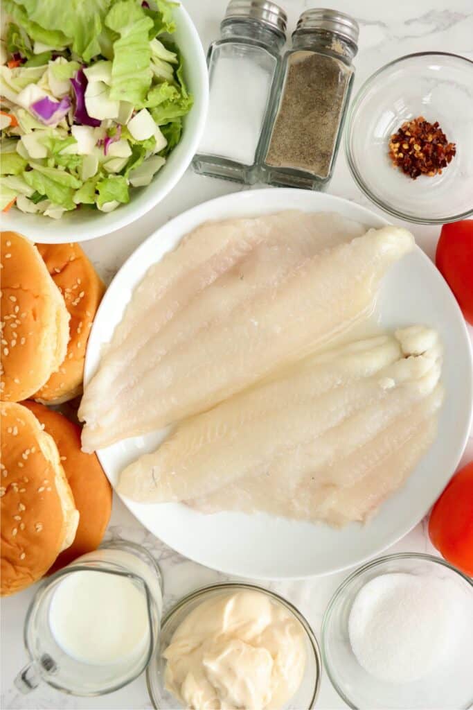 Overhead shot of individual catfish sandwich ingredients on table. 