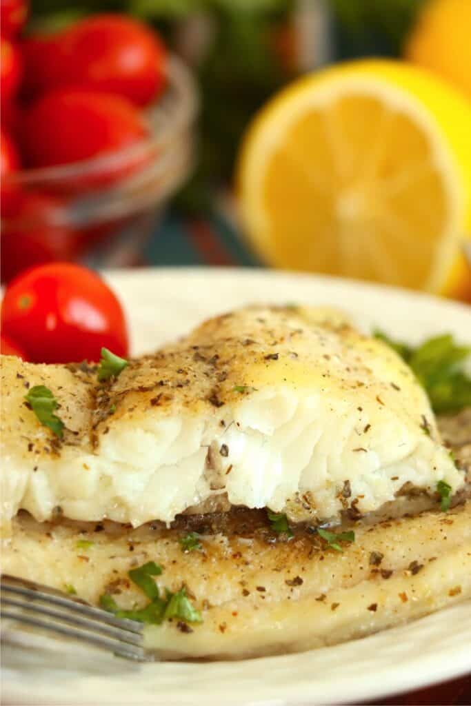 Closeup shot of two catfish steaks stacked atop one another with top steak cut in half. 