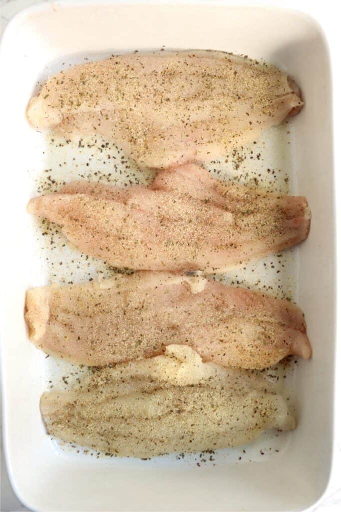 Overhead shot of seasoned catfish filets in baking dish. 