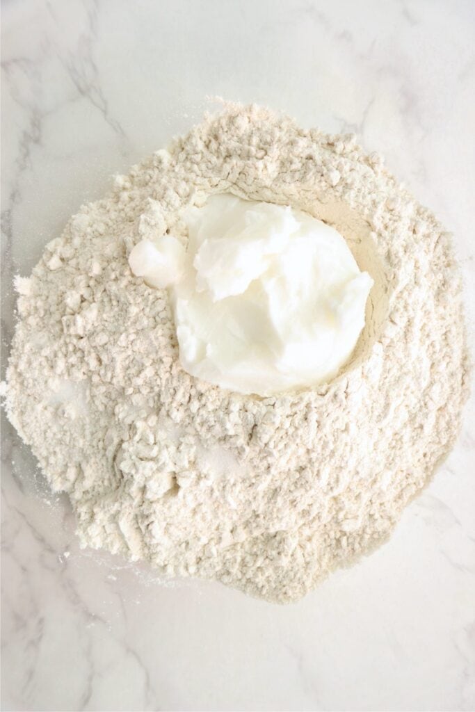 Overhead shot of mixing bowl with flour, shortening, and salt. 