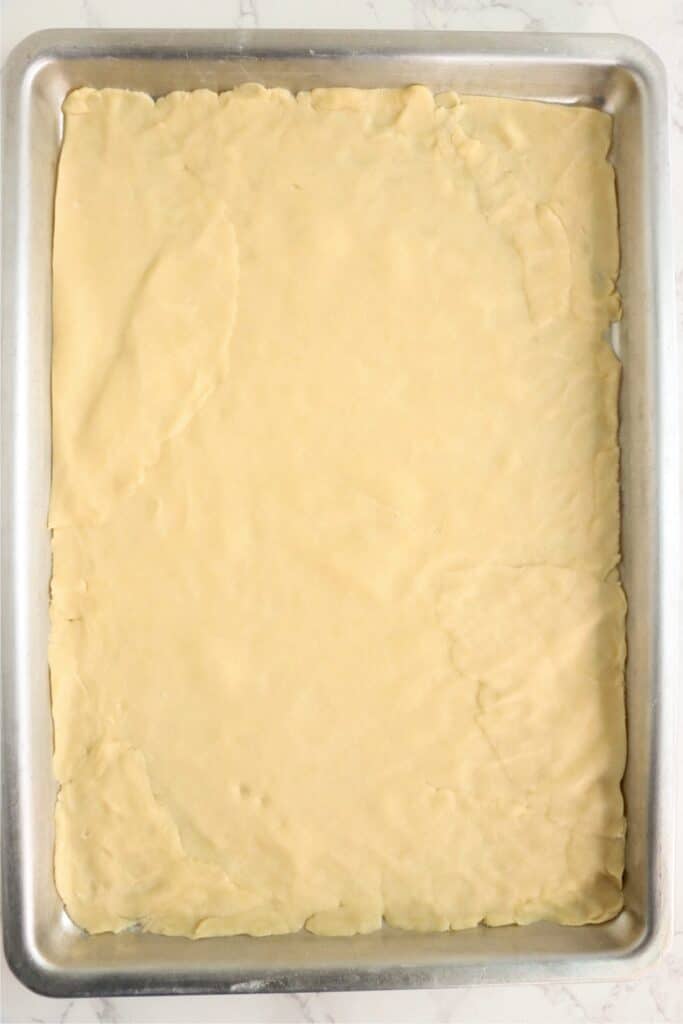 Overhead shot of crust dough in baking sheet.