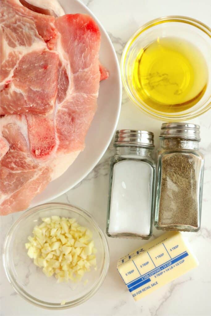 Overhead shot of individual reverse sear pork chop ingredients in bowls on table. 