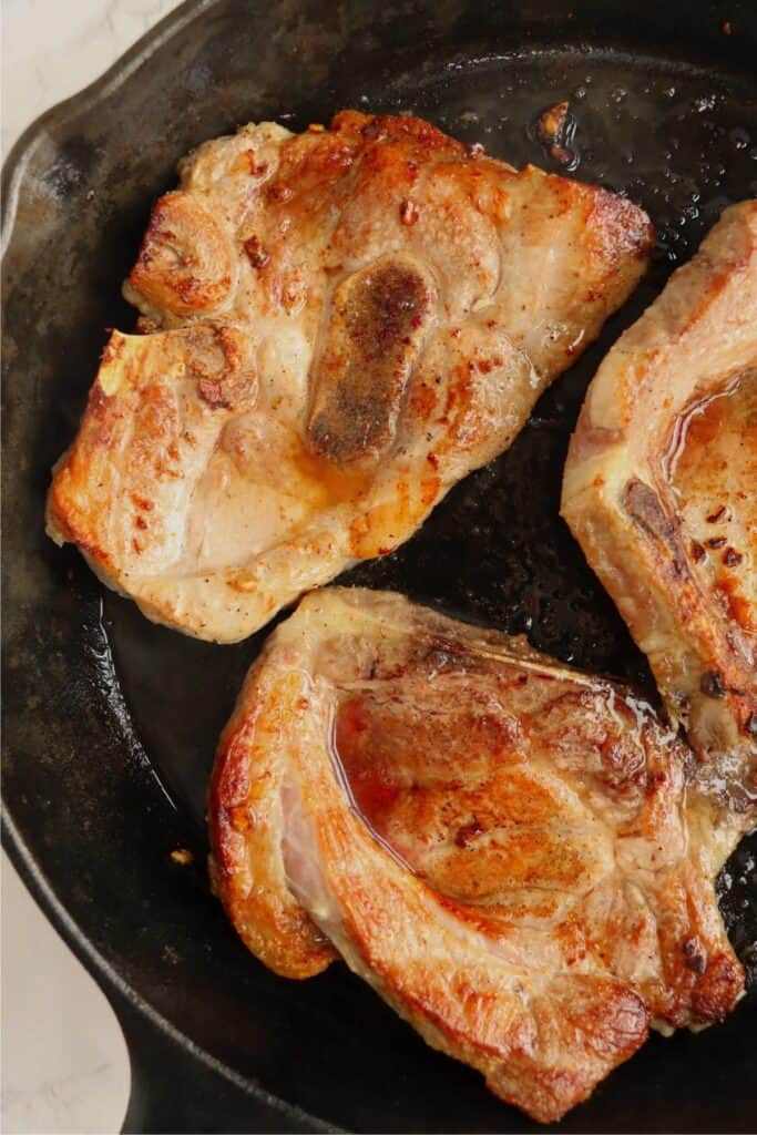 Closeup overhead shot of skilletful of reverse sear pork chops. 