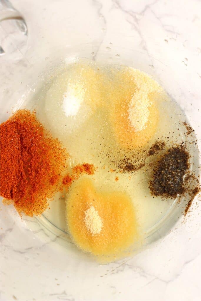 Overhead shot of mixing bowl with oil and seasonings.