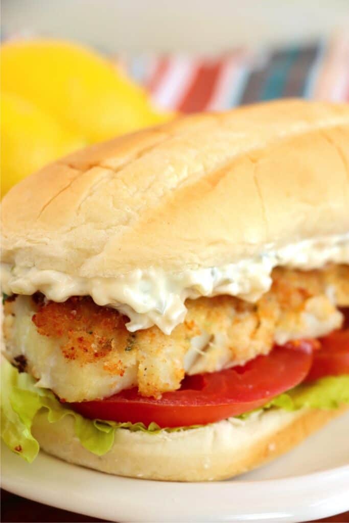 Closeup shot of cod sandwich on plate. 