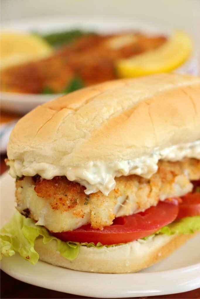 Closeup shot of breaded cod sadnwich on plate. 