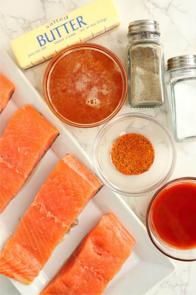 Overhead shot of hot honey salmon ingredients in individual containers on table. 