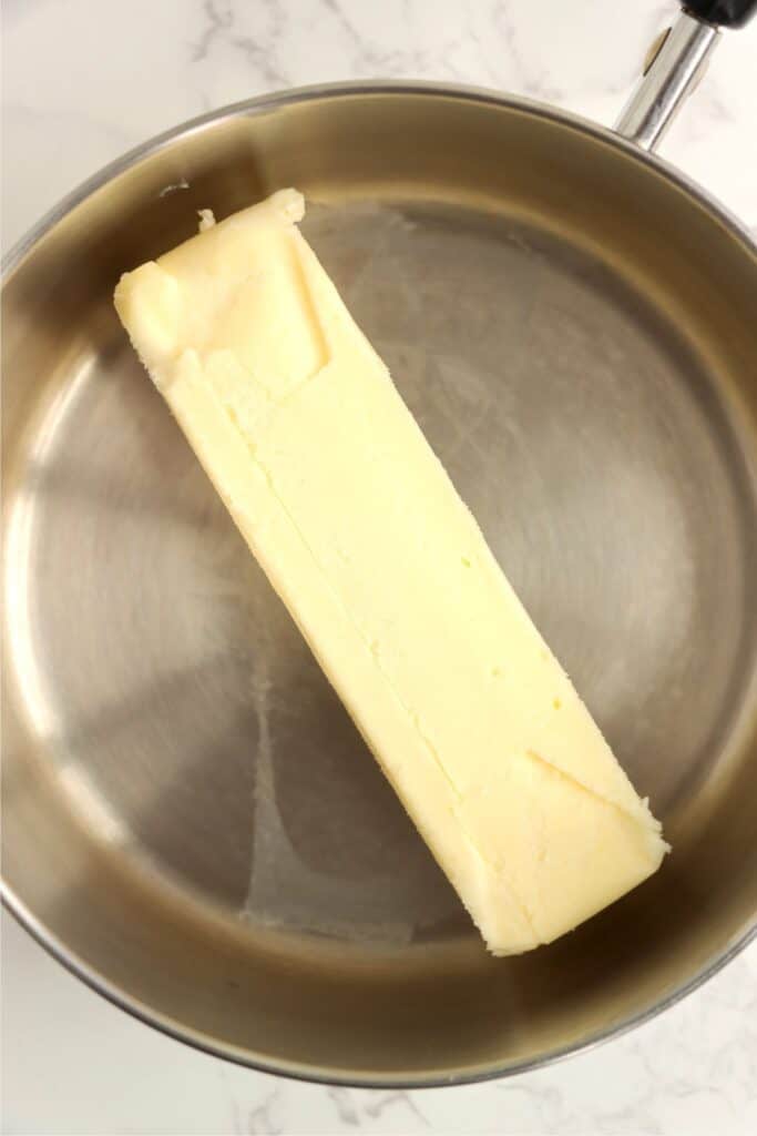 Overhead shot of stick of butter in saucepan. 