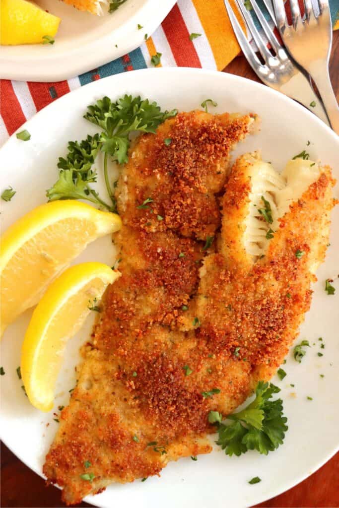 Overhead shot of parmesan crusted cod fillet on plate. 