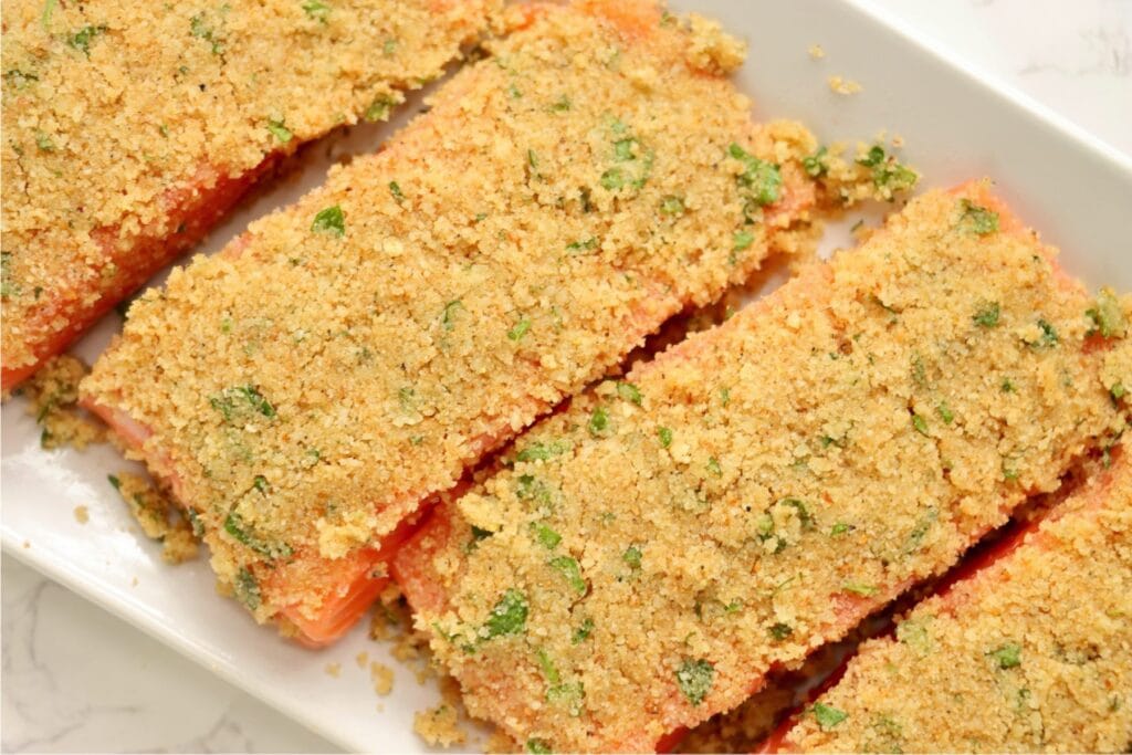 Overhead shot of unbaked herb crusted salmon fillets. 