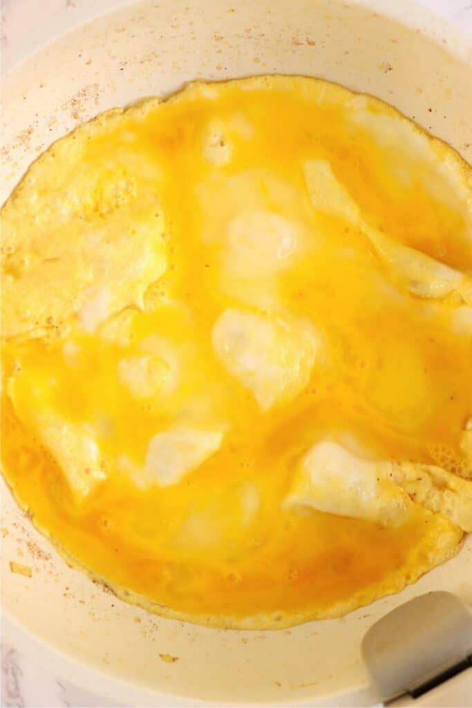 Overhead shot of eggs cooking in a skillet. 