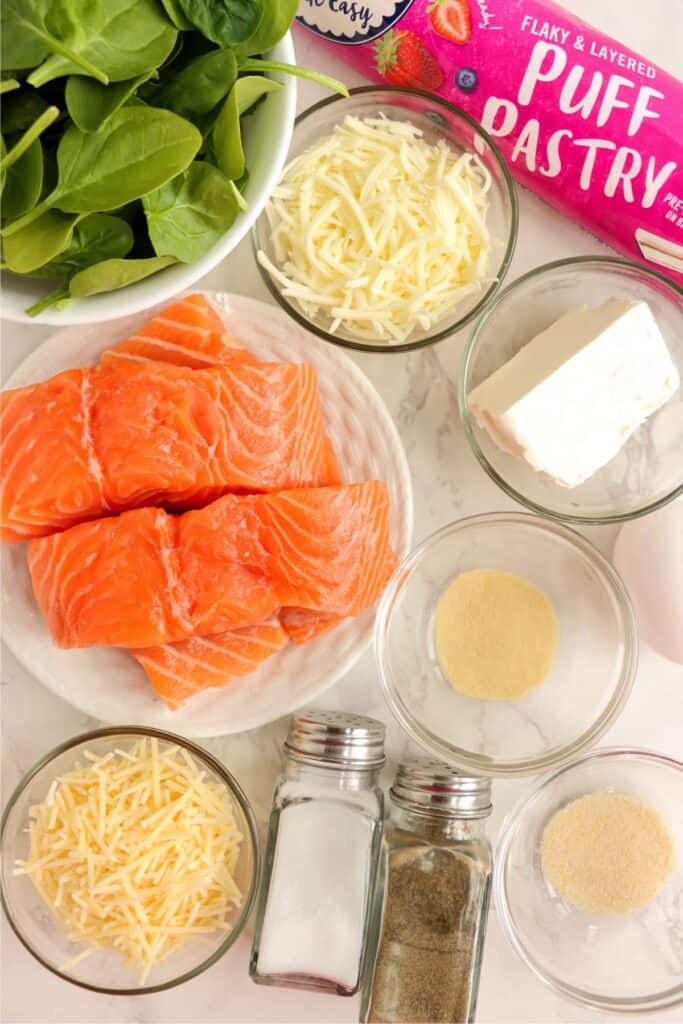 Overhead shot of individual salmon Wellington ingredients in bowls. 