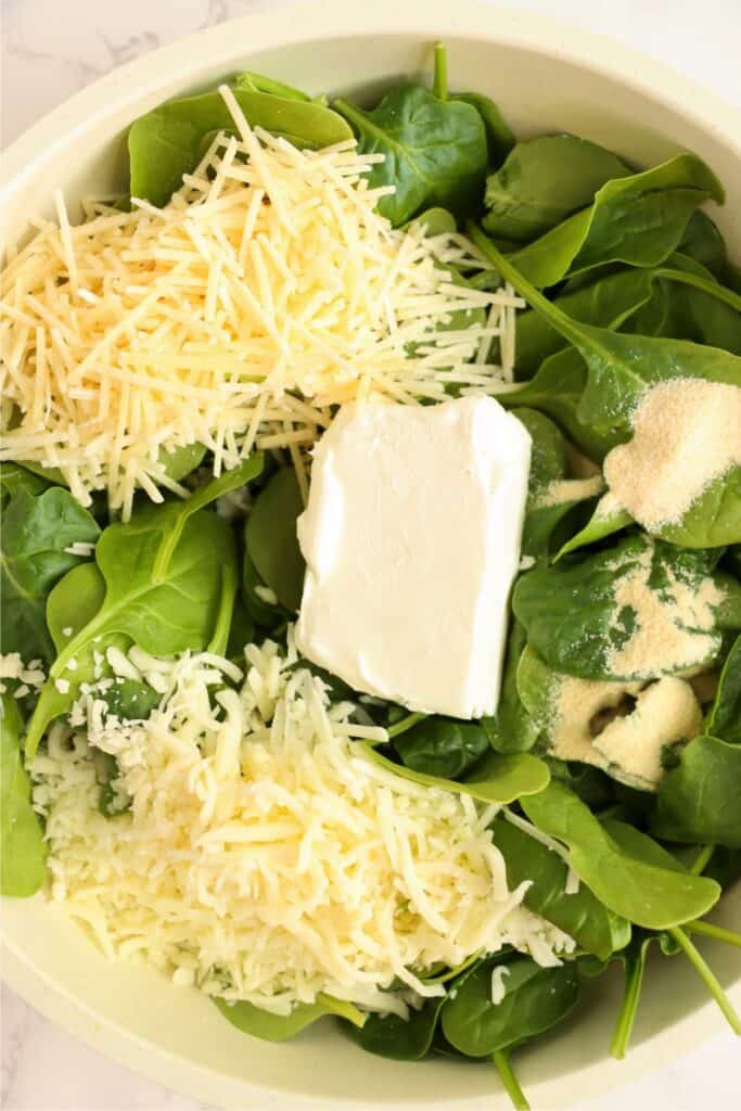 Overhead shot of spinach and cheese in skillet. 