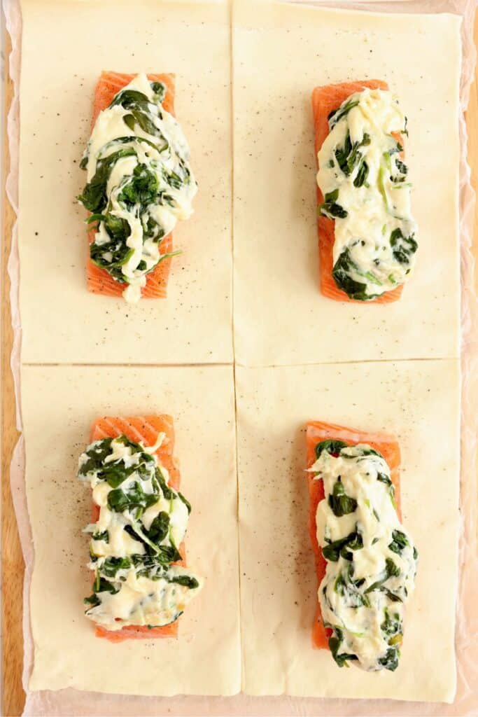 Spinach and cheese-topped salmon fillets on puff pastry rectangles. 