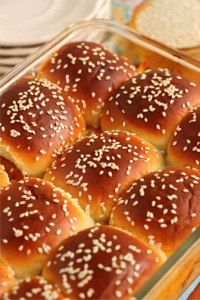 Closeup shot baked BBQ chicken sliders in baking dish. 