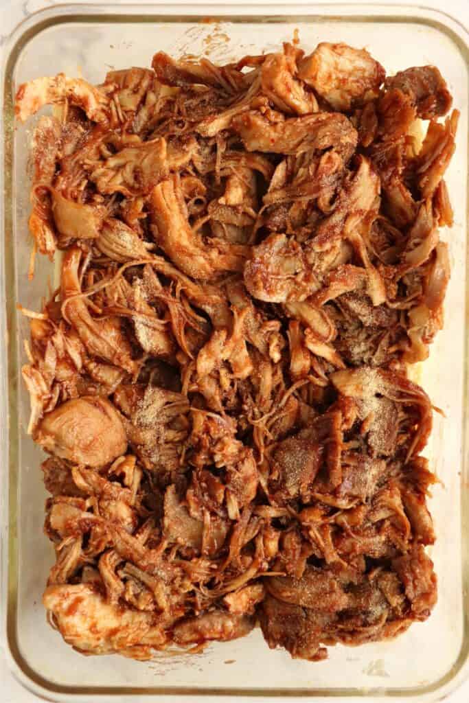 Overhead shot of Hawiian rolls topped with shredded BBQ chicken.
