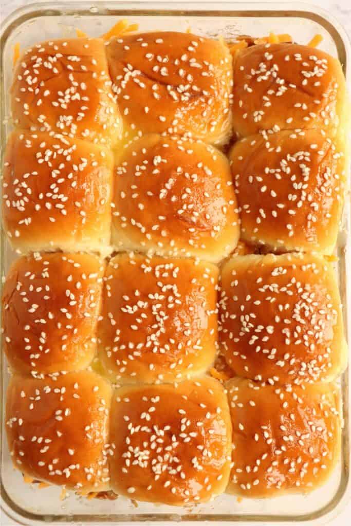 Overhead shot of unbaked BBQ chicken sliders topped with white sesame seeds. 