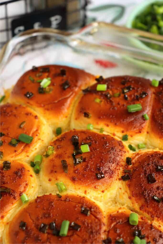 Closeup shot of baking dish full of baked crack chicken sliders. 