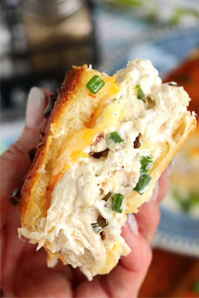 Closeup shot of hand holding a crack chicken slider. 