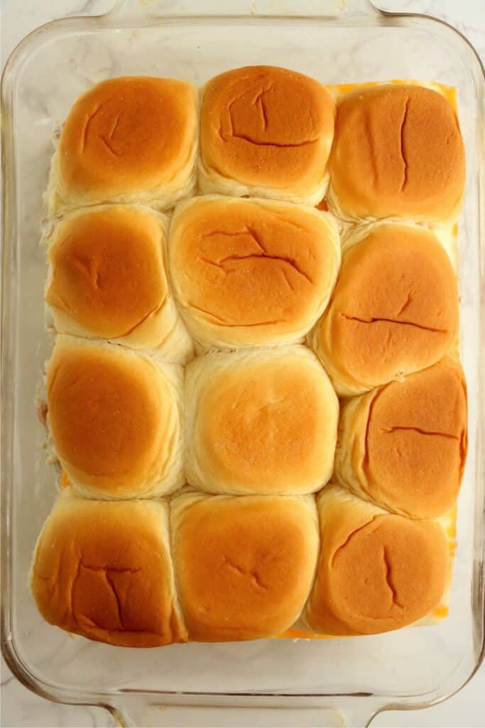 Overhead shot of unbaked crack chicken sliders in baking dish. 