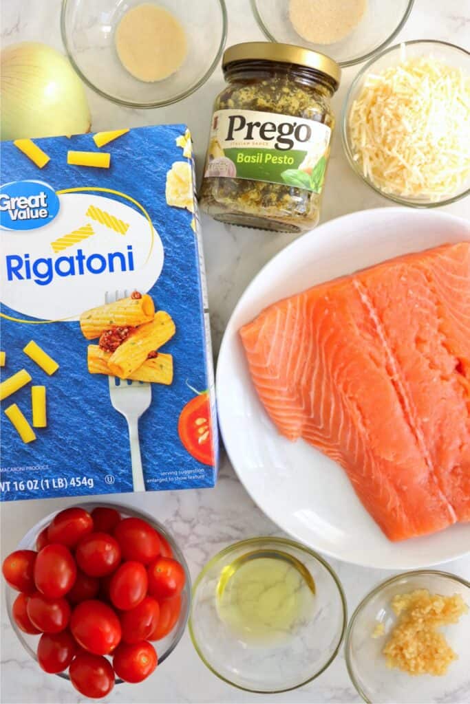 Overhead shot of individual salmon and pesto pasta ingredients. 