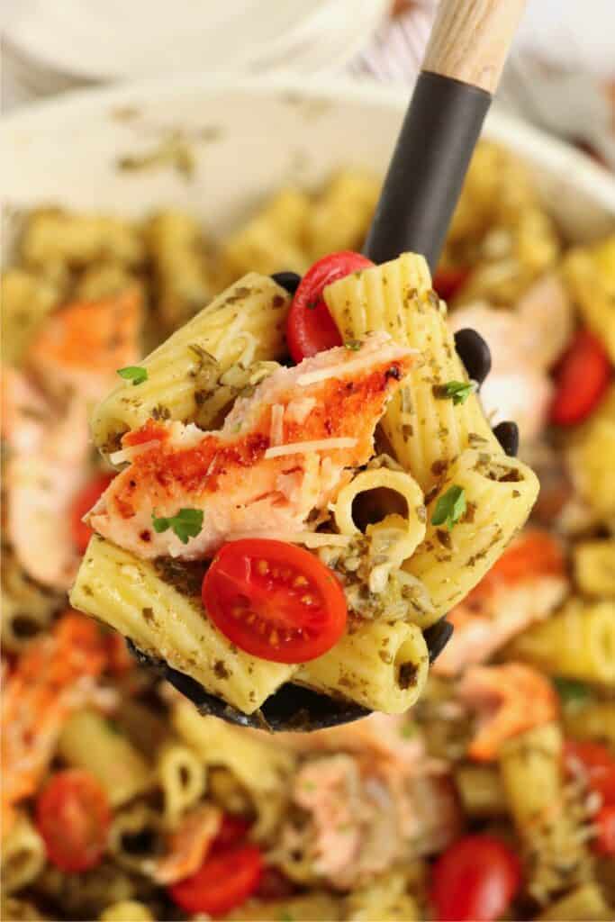  Closeup overhead shot of spoonful of salmon and pesto pasta. 