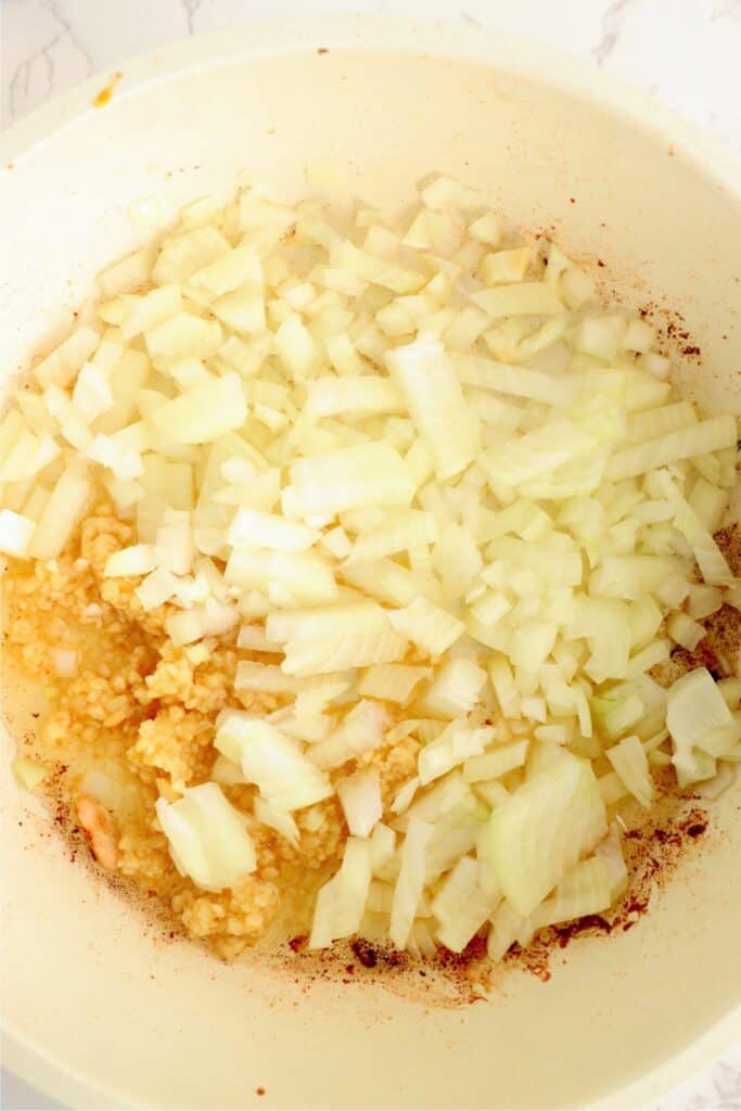 Overhead shot of onoins and garlic in skillet.