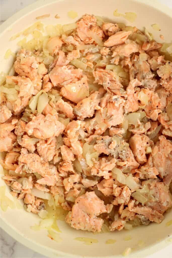 Overhead shot of skilletful of salmon and onions. 