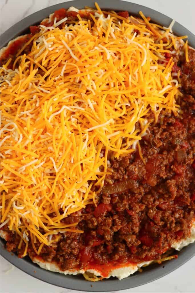 Overhead shot of spaghetti pie topped with cheese. 