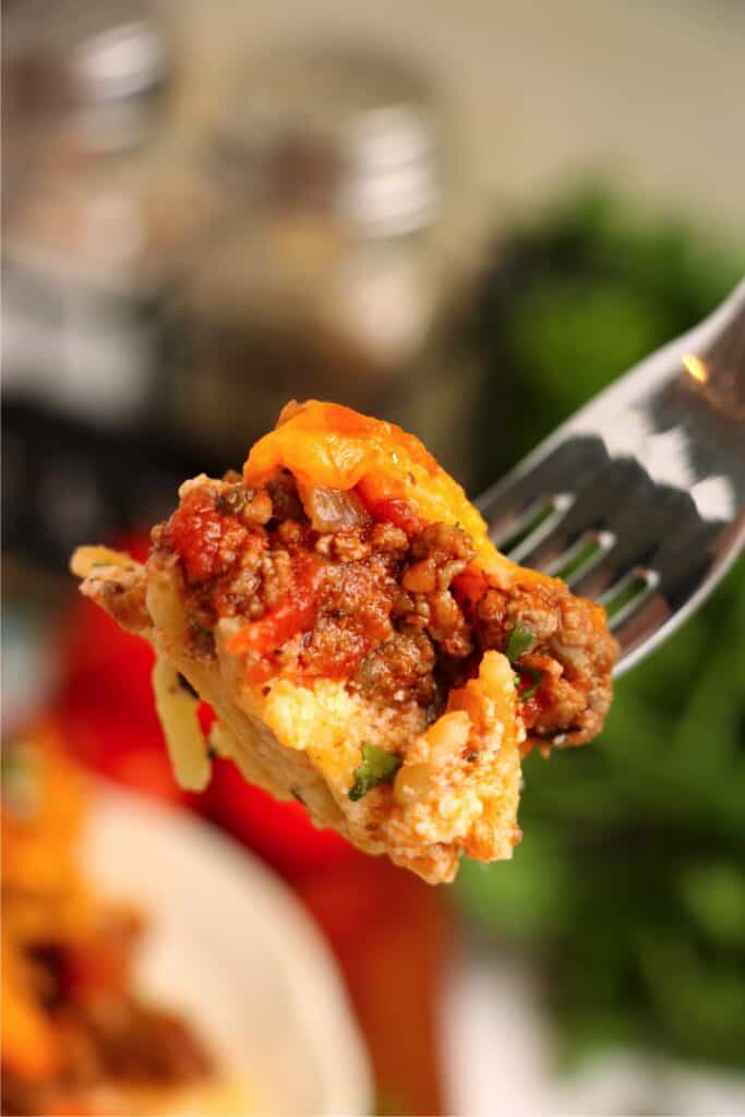 Closeup shot of forkful of spaghetti pie. 